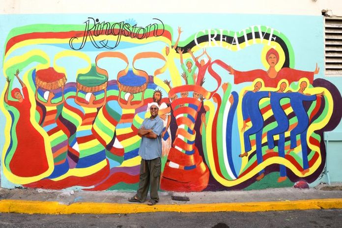 KC - Bernard Hoyes stands in front of his mural